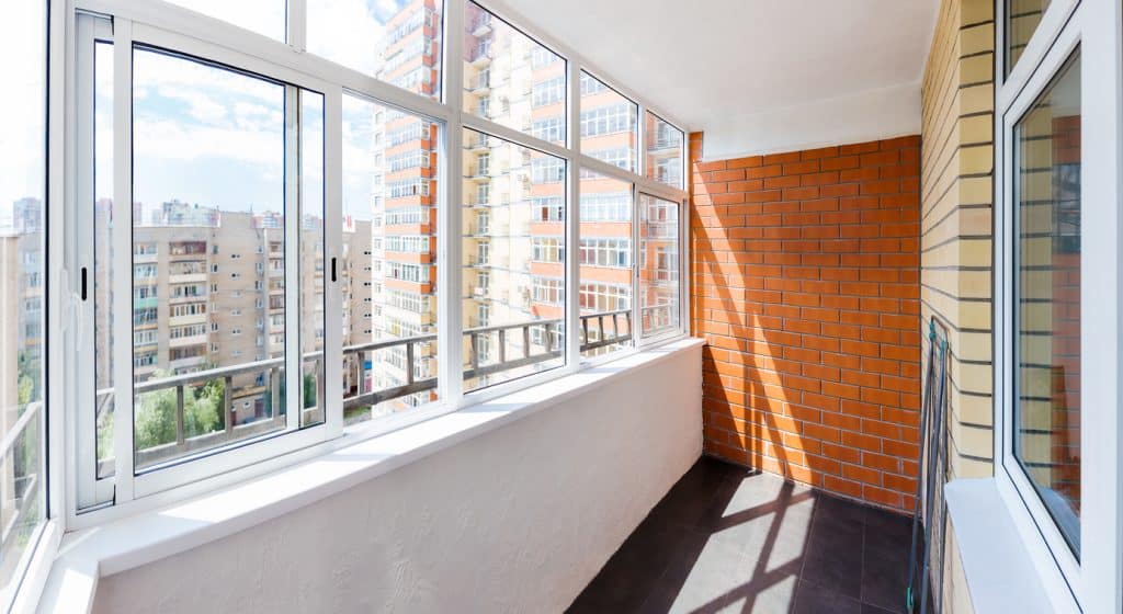 Glazed balcony with brick wall and sliding windows