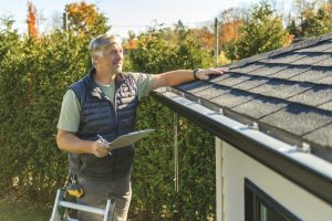 man inspecting roof